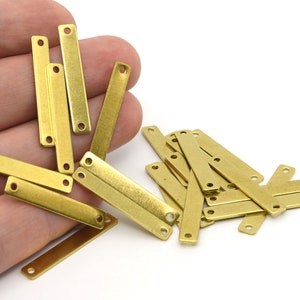 May include: A collection of small, rectangular brass metal connectors with two holes at each end. These jewelry findings are ideal for connecting various components in jewelry making and crafting projects. The connectors are a warm, golden color.
