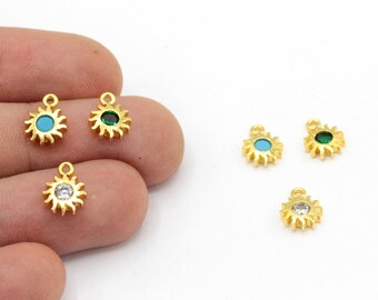 Può includere: Ciondoli a forma di sole color oro con centri in cristallo turchese, verde e trasparente. I ciondoli hanno un anello nella parte superiore per il fissaggio ai gioielli. Il design a raggiera è dettagliato e i ciondoli sono piccoli.