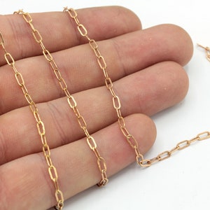 Op de afbeelding: Een goudkleurige ketting met langwerpige ovale schakels. De ketting wordt gepresenteerd tegen een lichte achtergrond, die het delicate ontwerp benadrukt. De ketting is een sieradencomponent, geschikt voor kettingen of armbanden.