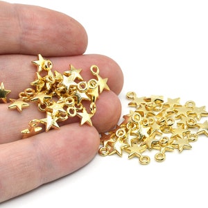 May include: A collection of small, gold-colored star charms. These charms have a shiny finish and are designed with a loop for easy attachment. Ideal for jewelry making or craft projects.