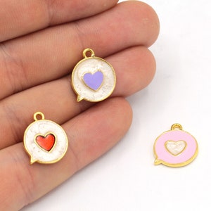 May include: Gold-coloured metal charms shaped like speech bubbles, each with a heart design. The hearts are red, lavender, and white. The charms have a gold border and a small loop for attaching to jewellery.