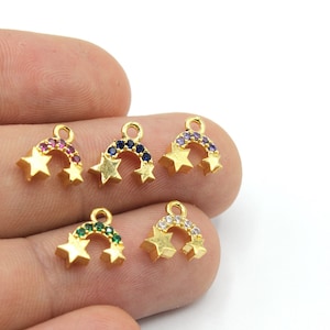 May include: Gold-coloured star charms with a rainbow arch of colourful gemstones. Each charm features two stars and a curved row of gems in various colours, including red, blue, purple, green, and clear.