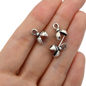 May include: Three silver-colored, open-design bead caps with a distressed finish. Each cap has a loop for stringing and a split design. These jewelry findings are ideal for beadwork and jewelry making.