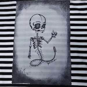 Könnte beinhalten: Eine Schwarzweißzeichnung eines Skeletts, das eine Kerze hält. Das Skelett sitzt mit gekreuzten Beinen auf dem Boden. Die Zeichnung befindet sich auf einem weißen Hintergrund mit schwarzem Rand.