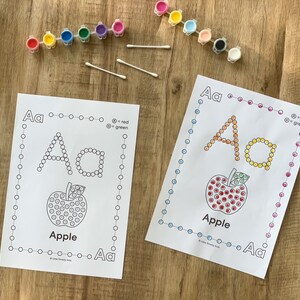 Pu&ograve; includere: Due fogli di attivit&agrave; didattiche con la lettera Aa e un'illustrazione di mela con contorni circolari per la pittura a puntini. Include due strisce di piccoli vasetti di vernice in vari colori e tre cotton fioc per l'applicazione.