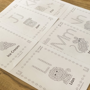 Pu&ograve; includere: Un set di fogli di attivit&agrave; educativi bianchi con disegni a linee nere di un aquilone, marmellata, nido, gelato, topo e leone. Ogni foglio include lettere dell'alfabeto formate da cerchi, chiavi di colore e etichette di testo corrispondenti.
