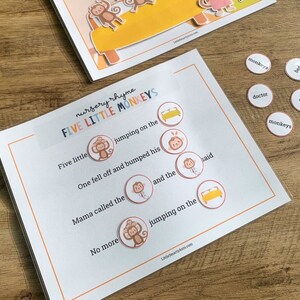 May include: A nursery rhyme activity sheet titled Five Little Monkeys with blank circular spaces for word placement. The sheet features printed text and illustrations of monkeys and beds. Several small circular tokens with words like monkeys, bed, and doctor are included.
