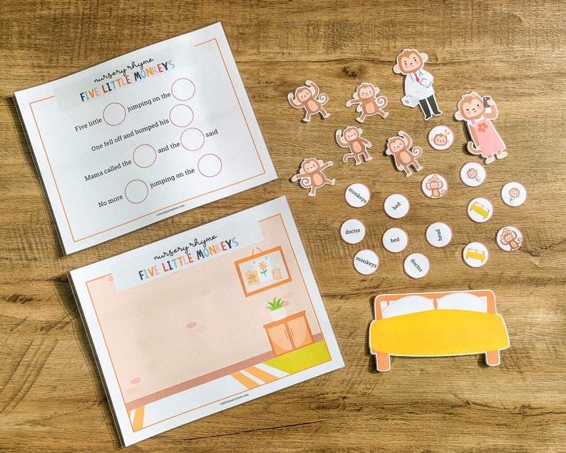 May include: A Five Little Monkeys nursery rhyme activity set featuring two printed sheets, one with text and blank circles, the other with a room illustration. Includes several small monkey cutouts, a doctor, a bed, and circular word tokens.