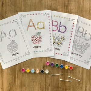 Pu&ograve; includere: Quattro fogli di attivit&agrave; bianchi con lettere Aa e Bb tratteggiate e illustrazioni di una mela e una farfalla. I fogli includono codici colore, due strisce di piccoli vasetti di vernice in vari colori e due cotton fioc bianchi per dipingere.