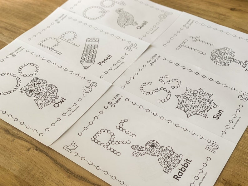 Pu&ograve; includere: Un set di fogli di lavoro educativi da colorare bianchi con le lettere dalla O alla T. Ogni pagina mostra una grande lettera formata da cerchi, un'illustrazione corrispondente come un gufo, una matita, una quaglia, un albero, un sole o un coniglio.