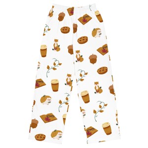 Peut inclure: Pantalon de pyjama blanc avec un motif répété de renards bruns, glands, tasses de café, tartes et hérissons lisant des livres.