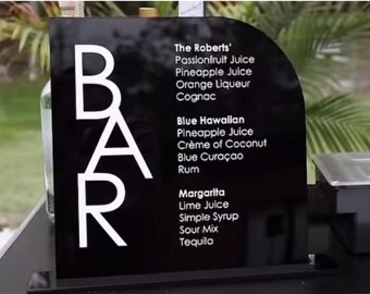 May include: Black sign with white text that says "BAR" and lists the ingredients for three cocktails: The Roberts', Blue Hawaiian, and Margarita.