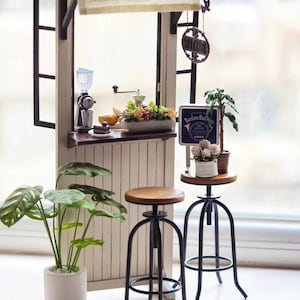 May include: A miniature dollhouse coffee shop with a white awning, two black metal bar stools, and a sign that reads "Barlow Bubbles, 8am - 5pm, The Espresso Bar".