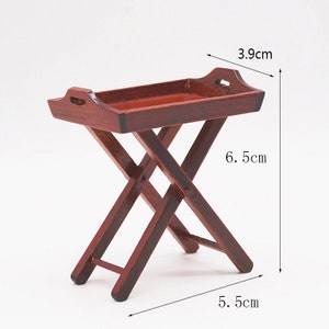May include: A wooden folding tray table with a dark brown finish. The table measures 6.5 inches tall, 5.5 inches wide, and 3.9 inches deep.