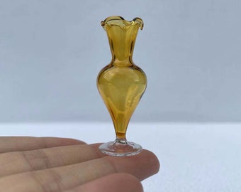 May include: A small amber glass vase with a ruffled top and a clear glass base.
