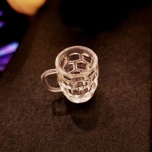 May include: A clear glass mug with a honeycomb pattern. The mug has a handle and is empty.