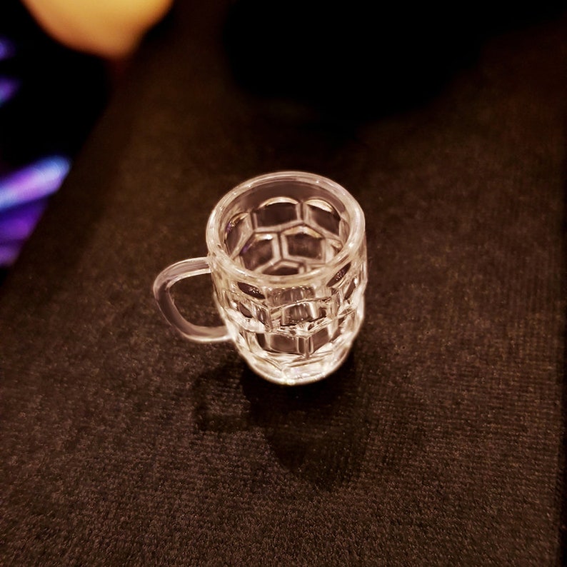 May include: A clear glass mug with a honeycomb pattern. The mug has a handle and is empty.