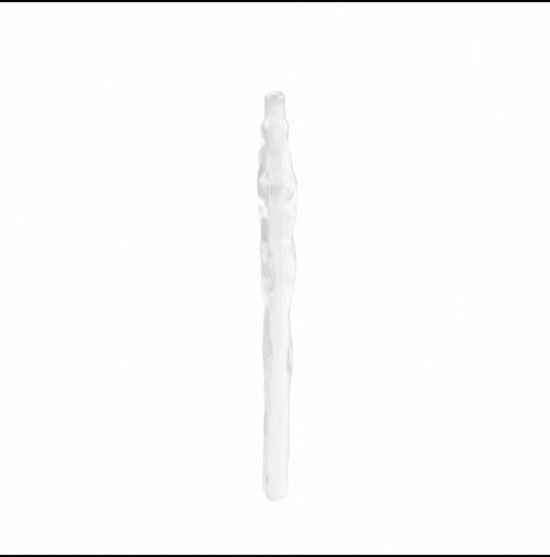 May include: A clear, elongated object with a textured surface, possibly glass or crystal. The object is vertically oriented against a white background, with a slightly irregular shape, suggesting it may be handmade.