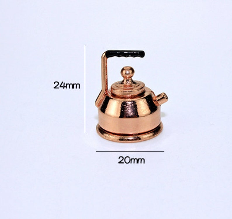 Pu&ograve; includere: Un bollitore in rame in miniatura con un manico nero. Il bollitore &egrave; alto 24 mm e largo 20 mm.