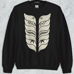 May include: Black sweatshirt with a white graphic of two stylized feathers with the words "Hold Fast" written on them.