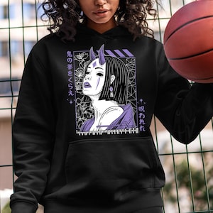 Puede incluir: Sudadera negra con un estampado gráfico morado y blanco de una mujer con cuernos y flores. El texto en el gráfico dice "鬼の夢をくらえ" y "呪われた".