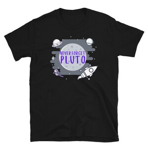 May include: Black t-shirt with a white graphic of a cartoon astronaut, a rocket, a planet, and a UFO. The text "Never Forget Pluto" is written in purple.