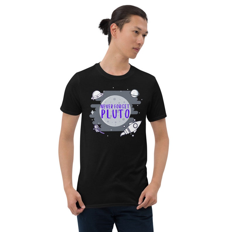 May include: Black t-shirt with a graphic of a moon, stars, a rocket, and a UFO. The text "NEVER FORGET PLUTO" is written in purple on the moon.