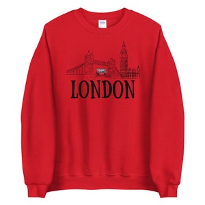 May include: Red sweatshirt with a black outline of the London skyline, including Big Ben and Tower Bridge, and the word "LONDON" in black text.