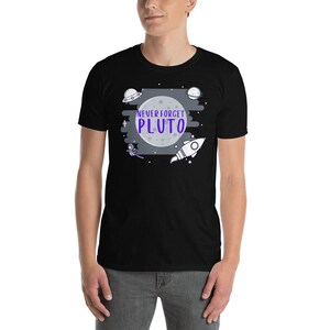 May include: Black t-shirt with a white moon, stars, and a rocket ship. The text "NEVER FORGET PLUTO" is in purple.