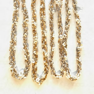 May include: Four strands of shell necklaces, each with a silver clasp. The shells are a mix of white and brown.