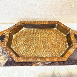 May include: Octagonal woven tray with a brown and beige pattern. The tray has two handles on the sides and a raised rim.
