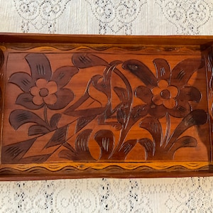Bandeja de madera con doble asa. Grabado a mano con aves y flores. Bandeja para servir frutas o servir. Origen sudamericano. 45 cm de largo.