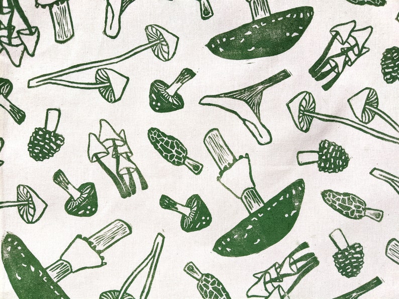 May include: A white fabric with a green repeating pattern of various mushrooms. The mushrooms are drawn in a simple, stylized way.