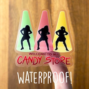 May include: A clear sticker with three silhouetted figures in front of spotlights. The text "Welcome to my Candy Store" is in red and the text "Waterproof!" is in white.