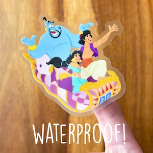 May include: A clear sticker featuring Aladdin, Jasmine, and Genie from Disney's Aladdin. The characters are riding on a magic carpet. The sticker is labeled "Waterproof!"