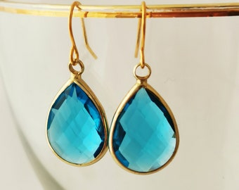 Bright blue faceted glass teardrop shape earrings. Gold plated, nickel free, hypoallergenic
