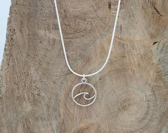May include: A silver chain necklace with a circular pendant featuring a wave design.