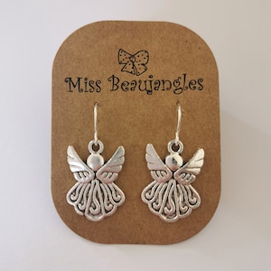May include: Silver angel earrings on a brown card with the text "Miss Beaujangles".