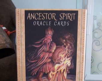 May include: A box of "Ancestor Spirit Oracle Cards" by Jade Sky, illustrated by Belinda Morris. The box features a colorful illustration of a figure with long hair and a headdress, standing in front of a fire.