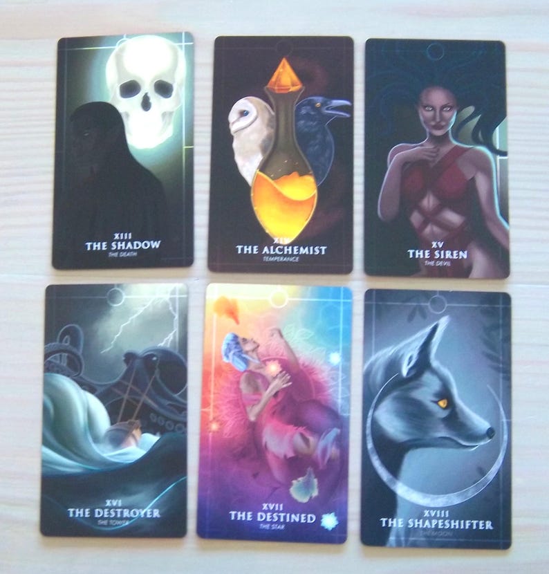 May include: Tarot card deck featuring illustrations of the Shadow, the Alchemist, the Siren, the Destroyer, the Destined, and the Shapeshifter. Each card has a unique design and imagery.