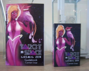 May include: Two Tarot in Space Cosmic Zen Guidebooks with a purple and black cover featuring a woman with a pink outfit and a purple bird. The text on the cover reads "Tarot in Space Cosmic Zen Guidebook Carmen Laup".
