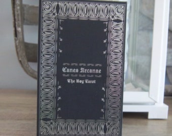 May include: A black box with a silver border and the text "Canes Arcanae The Dog Tarot" on the front.