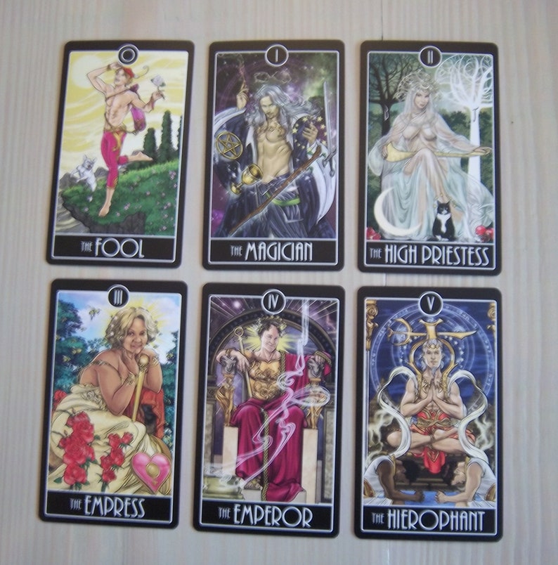 May include: A set of ten tarot cards with black borders and colorful illustrations. The cards are numbered from 0 to 9 and feature images of The Fool, The Magician, The High Priestess, The Empress, The Emperor, The Hierophant, The Lovers, The Chariot, Strength, and The Hermit.