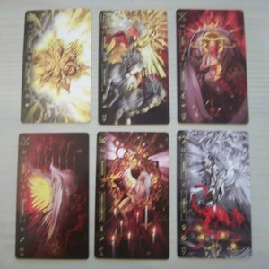 May include: Six tarot cards with gold trim and black backgrounds. The cards feature illustrations of angels and other figures in various poses. The cards are numbered 1-6 and have the names of the corresponding tarot cards written on them.