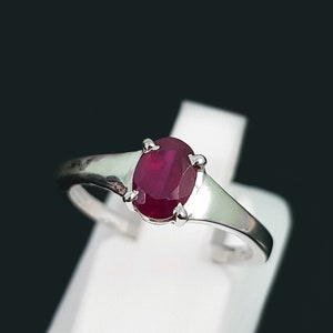Peut inclure: Une bague en argent avec une pierre précieuse ovale rouge rubis.
