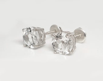 May include: A pair of silver stud earrings with clear round gemstones.