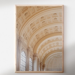 May include: A photograph of a grand, ornate interior with a high vaulted ceiling. The ceiling is made of white plaster and features intricate patterns of arches and moldings. The walls are also white and have large windows that let in natural light. The overall effect is one of grandeur and elegance.