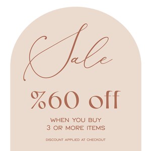 May include: A peach-colored arch with the word "Sale" in a brown cursive font. The text below reads "60% off" in brown font. The text below that reads "When you buy 3 or more items. Discount applied at checkout."