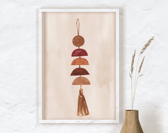 May include: Abstract watercolor art print in a white frame. The artwork features a series of brown and red geometric shapes, including a circle, half-circles, and a tassel. The background is a light beige color.