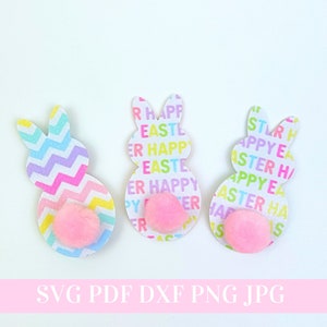 May include: Three Easter bunny cutouts with pink pom-poms for tails. The bunnies are decorated with a colorful chevron pattern and a repeating pattern of "Happy Easter" in different colors.